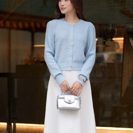 High-end fashion shimmer sweater with round neck and decorative stone buttons