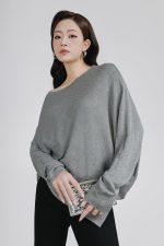 High-end sweater with crew neck, batwing sleeves and fashionable asymmetrical hem