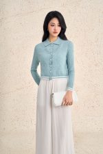 High-end sweater with V-neck, long sleeves, and striped hem to create a button-front style