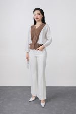 High-quality knitted sweater with V-neck, loose shape, batwing sleeves, buttoned body, styled with elastic hem